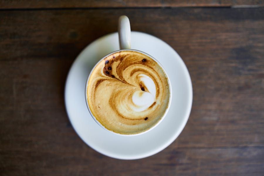 A flat white being handed across the pop-up counter.